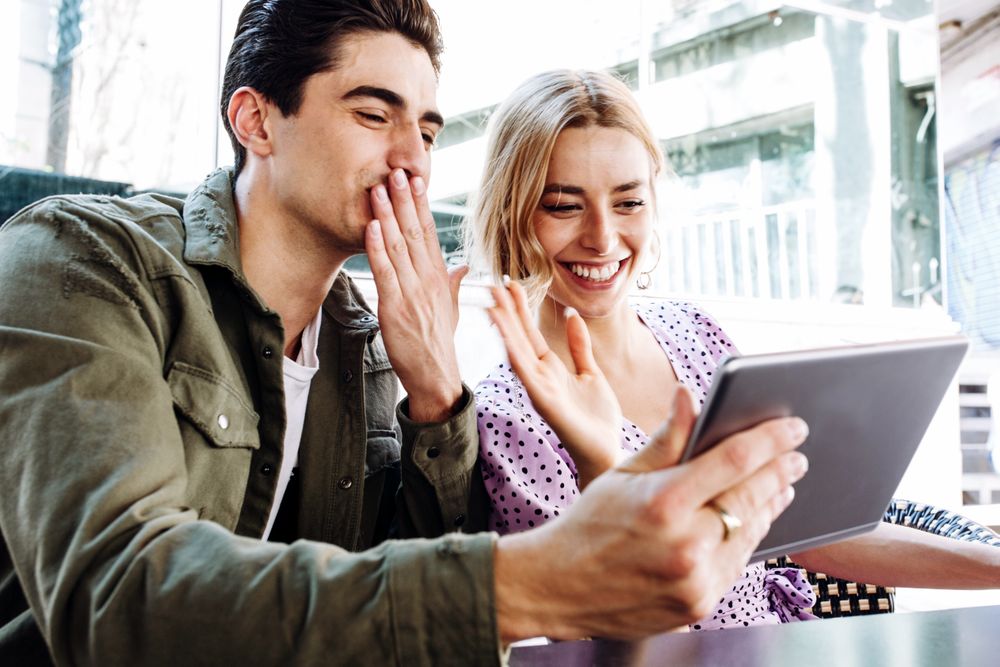 Happy young couple using tablet outdoors