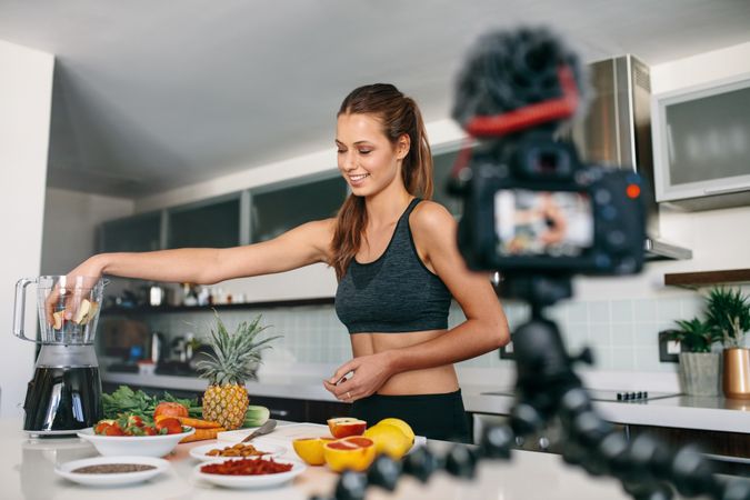 Fit woman recording content for vlog in kitchen