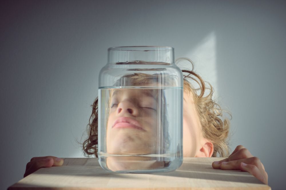 Napping boy near glass jar of water