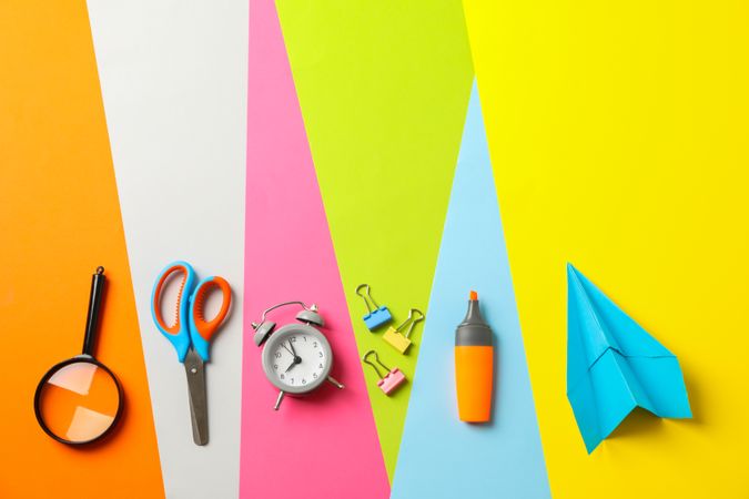 Flat lay composition with school supplies on multicolor background, space for text
