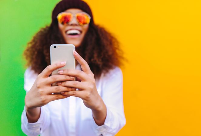 Curly haired woman taking a selfie using smartphone