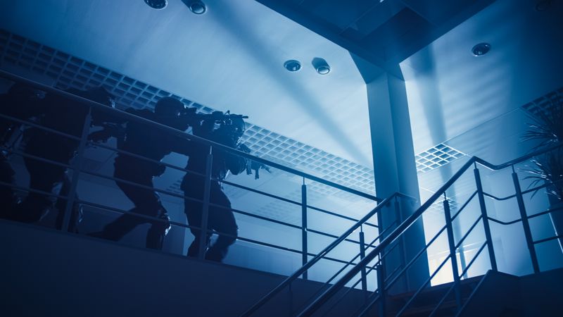 Masked Squad of Armed SWAT Police Officers Move in Formation on a Second Floor in a Dark Office Building.
