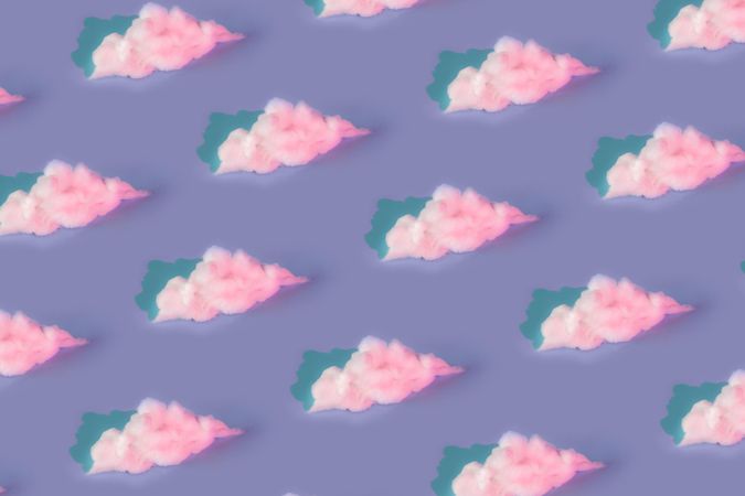 Pattern made of clouds of cotton wool in holographic neon colors on pastel purple background