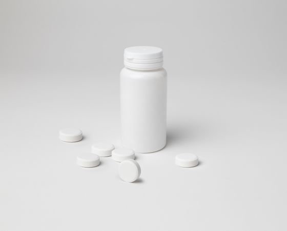 Mockup of a closed aspirin bottle, small size, on background with copyspace
