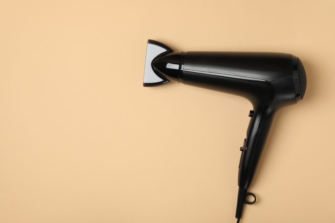 hair dryer on beige background, space for text