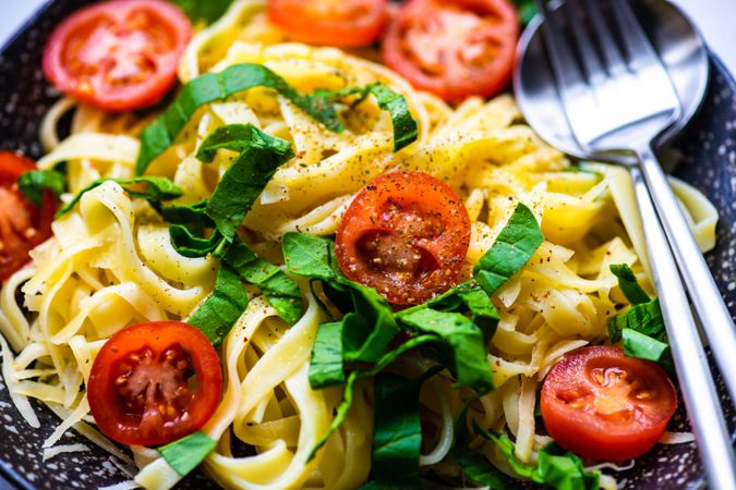 Close up of pasta with spinach and tomatoes