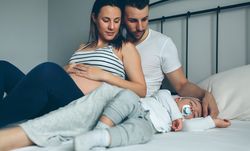 Pregnant woman with her husband looking son