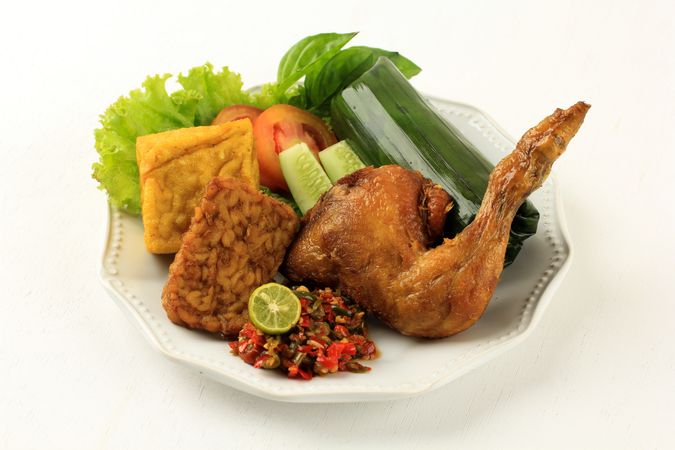 Indonesian chicken dish with vegetables and tempeh patties