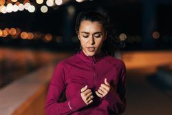 Woman in dark red sportswear jogging in the evening