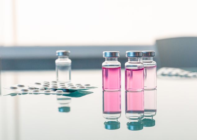 Vials with scientific samples arranged on glass table
