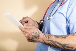 Cropped shot male healthcare worker using digital tablet