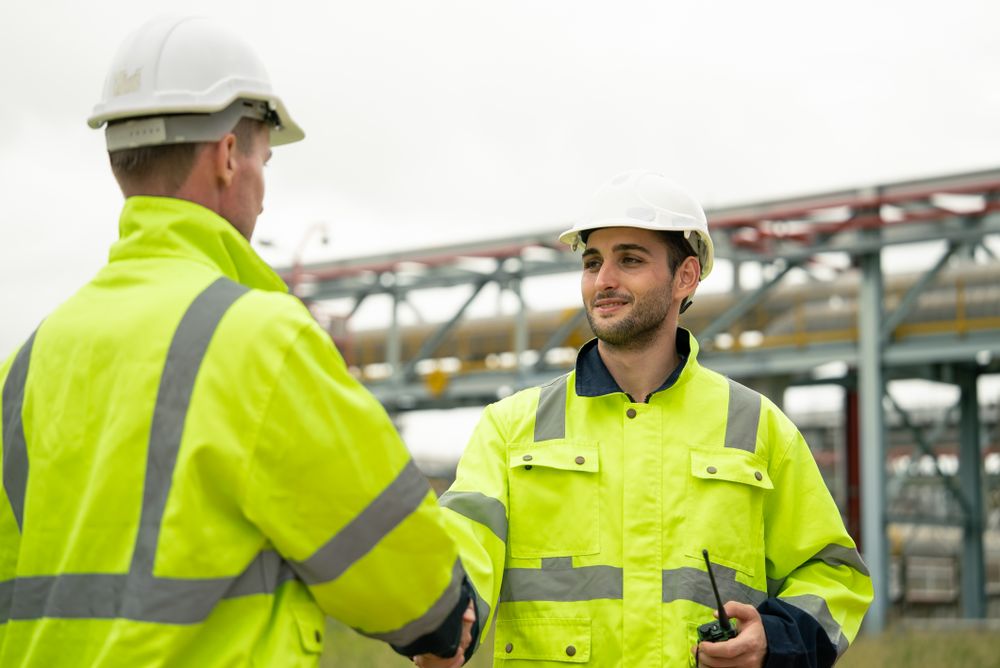 Engineer worker hand shaking to colleagues team for success work