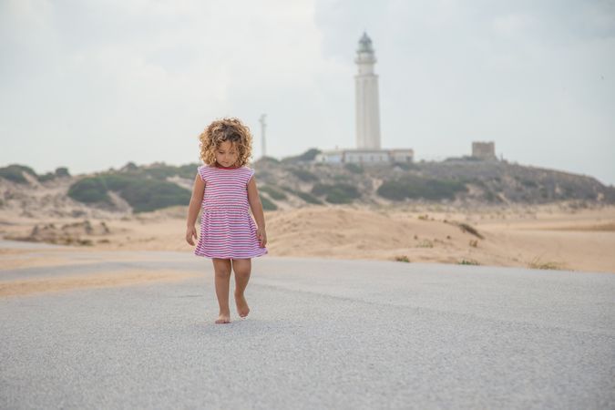 Little girl walking on beach seashore