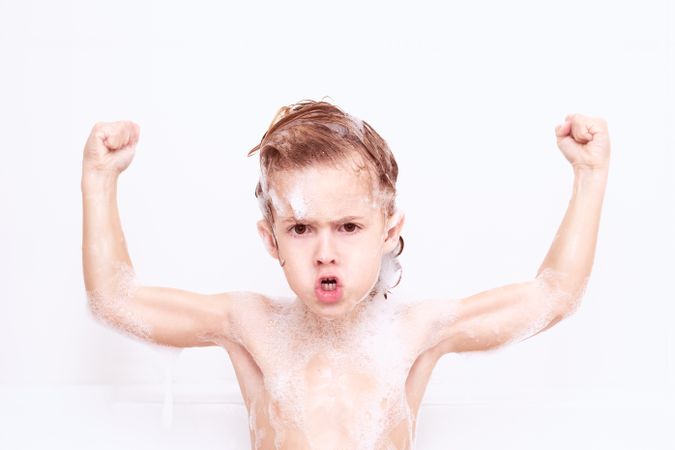 Boy showing strength in bathroom