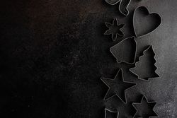 Christmas cookie cutters on dark background