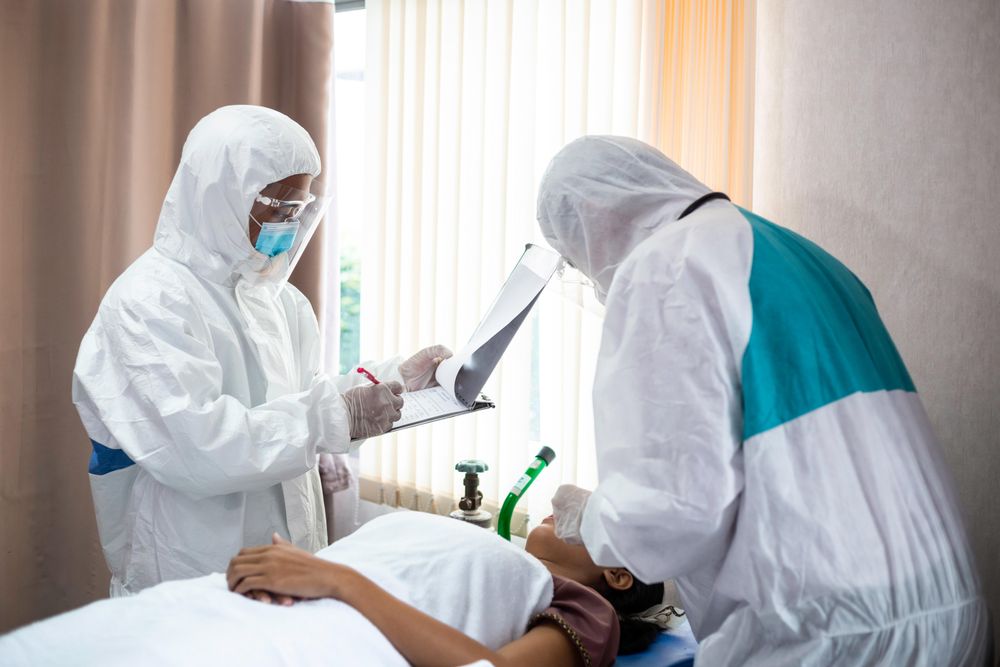 Paramedics in PPE in hospital with patient