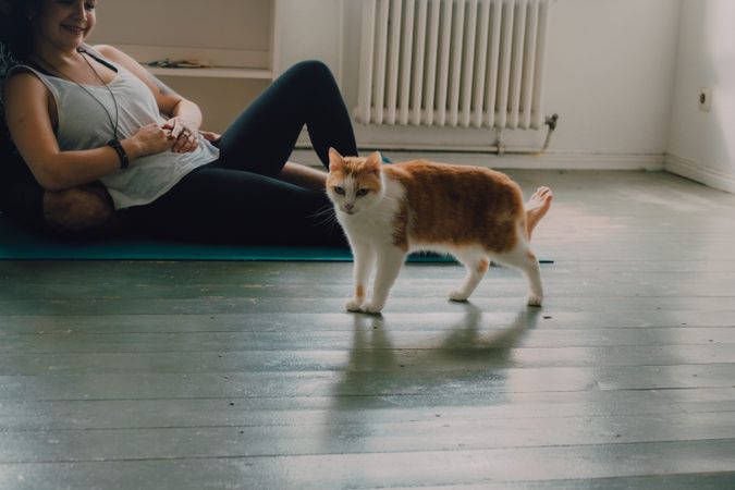 Loving couple cuddling on floor while cat walking around