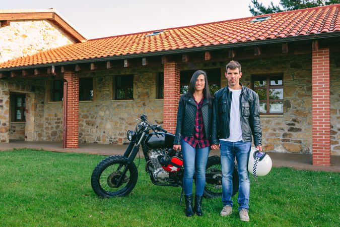 Couple posing holding hands and custom motorcycle