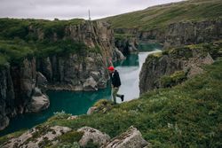 Man walking on cliff over water