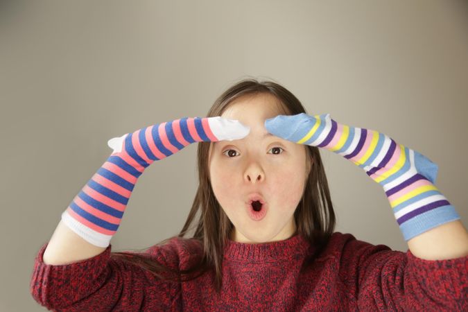 Surprised girl wearing socks on her hands