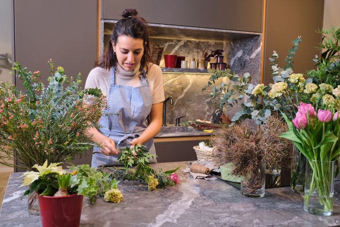 Female florist in apron cutting flowers
