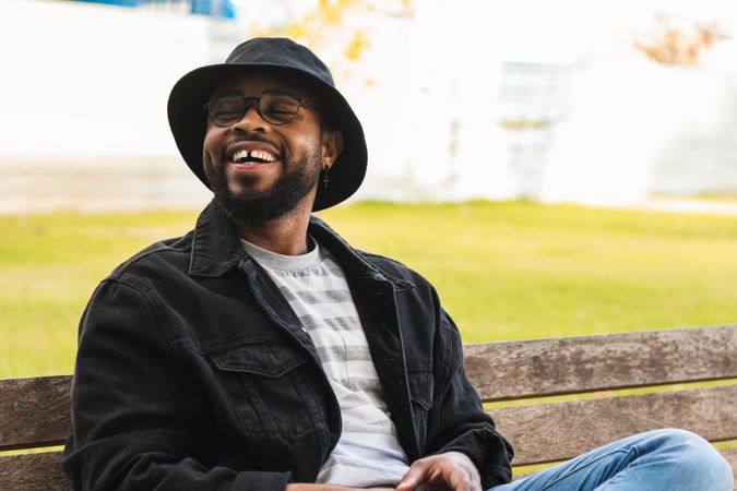 Trendy Black man sitting on bench