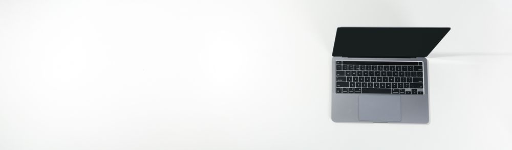 Top view banner of opened silver laptop and keyboard on desk with copy space