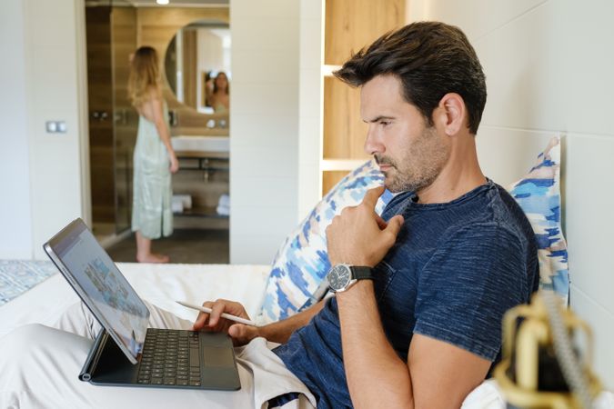 Thoughtful male freelancer using tablet during remote work
