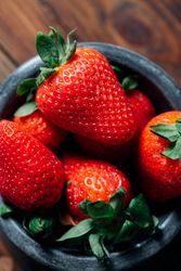 Fresh ripe strawberries in concrete bowl