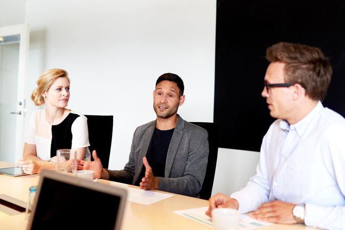 Three colleagues having a discussion in the board room