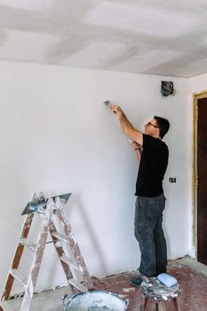 Bricklayer repairing the wall with a spatula