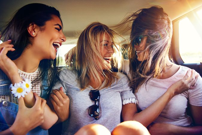 Group of female friends happily riding in back of vehicle