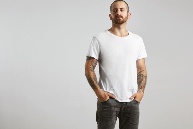 Tattooed man in plain bright t-shirt and jeans