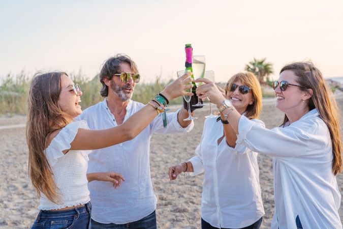Happy family drinking wine on beach