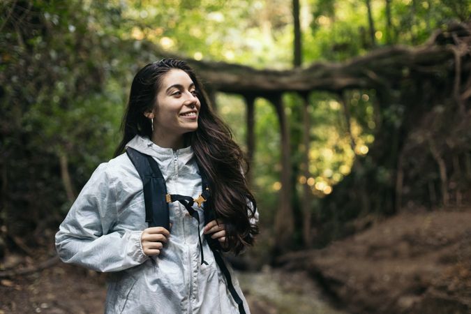 Smiling young woman walking in a forest