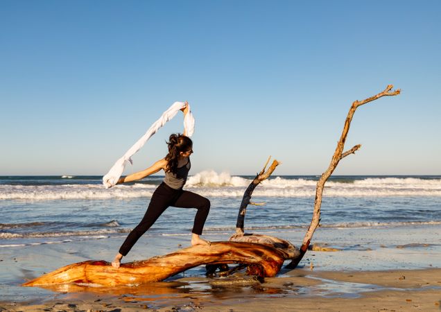 Young woman dancing and posing near water on shore