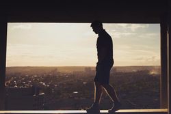 Silhouette of man balancing on top of building