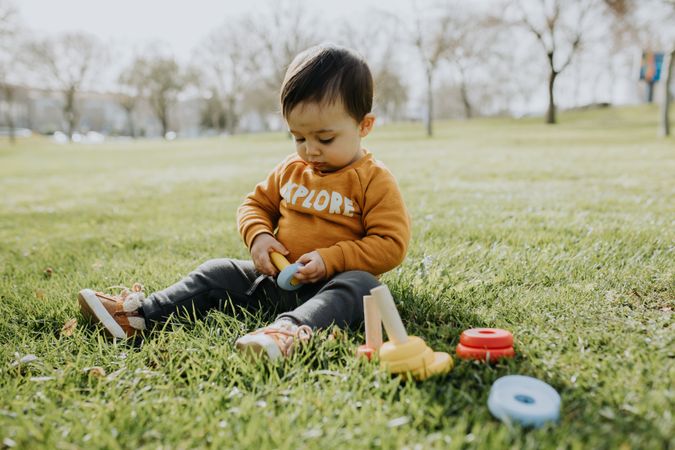 Cute toddler playing with his toys in a park