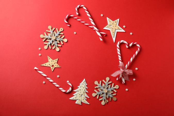 Candy canes and christmas accessories on red background, space for text