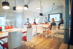 Group of people discussing a chart at a meeting in an open modern office