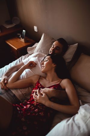 Happy couple cuddling on bed
