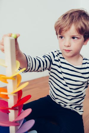 Boy playing with wooden construction pieces
