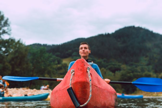 Young female kayaking on nature background