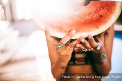 Woman holding a watermelon slice on a sunny day QbDar0