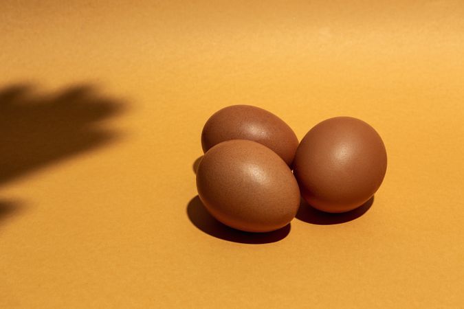 Fresh raw eggs on brown background