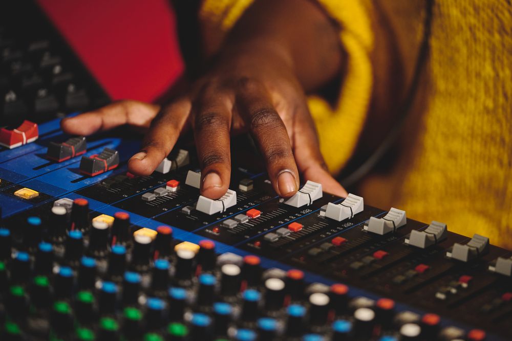 Unrecognizable sound engineer working on mixing console