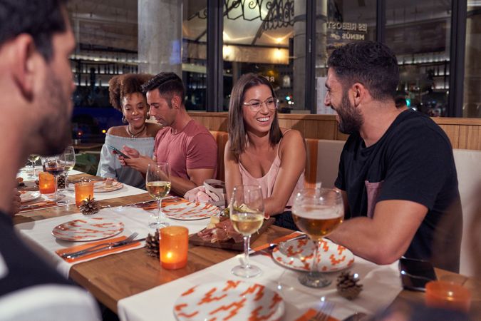 Diverse company of friends chilling in cozy pub in evening