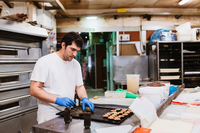 Crop baker squeezing dough on tray