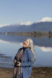 Happy photographer laughing by a mountain lake