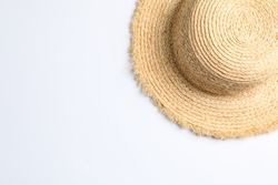 Pretty straw hat on neutral background. Space for text, top view